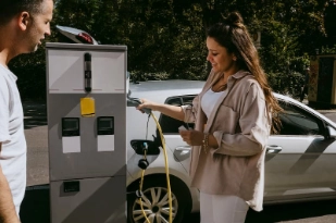 Une femme recharge sa voiture électrique à une borne