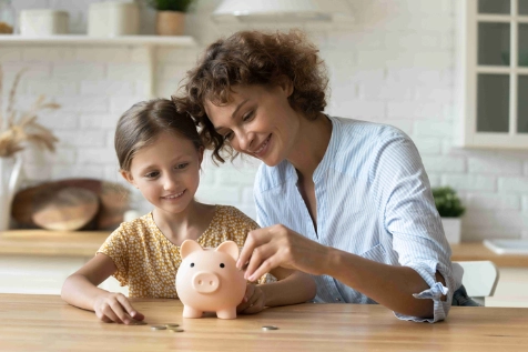 Une mère de famille enseigne à une petite fille à gérer son argent avec une tirelire en forme de cochon