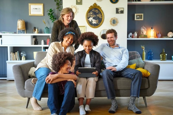 Une famille réunie autour d'une tablette tenue par la fille ainée