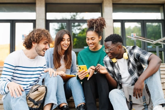 Des adolescents assis, consultent une application bancaire sur un mobile 