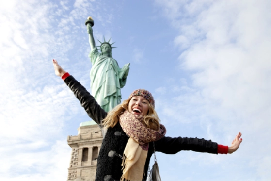 Femme en voyage à New-York devant la Statue de la Liberté
