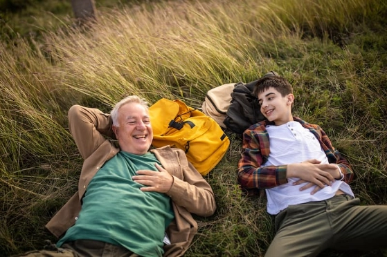 Grand-père et petit-fils allongés dans un champ