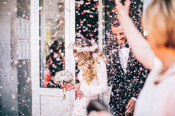 Un couple venant de se marier sort sous une pluie de confettis