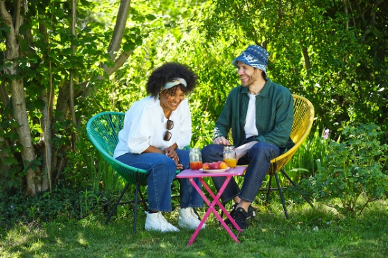 Jeune couple qui rit assis dans un jardin.  