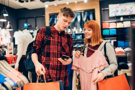 Deux adolescents, une fille et un garçon font du shopping dans un magasin de vêtements