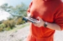 Une main tient un smartphone affichant la gestion de budget de l'App Orange Bank