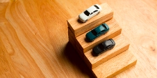 Des voitures jouets sont disposées sur un petit escalier en bois