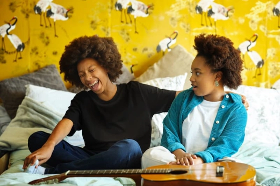 Deux adolescents s'amusent avec une guitare